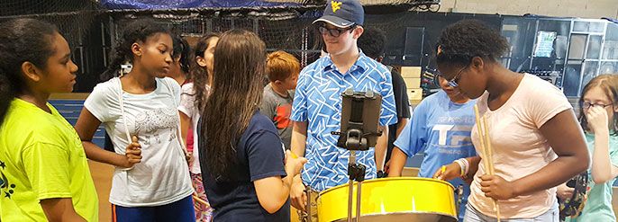 Students learning to play a steel drum